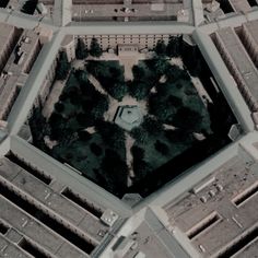 an aerial view of a building with trees in the middle