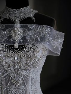 the back of a wedding dress with beading and pearls on it's neck