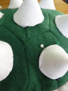 a green and white stuffed animal sitting on top of a table