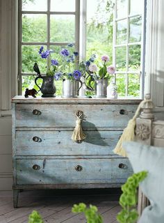 an old dresser with flowers in vases on top and the words simplity above it