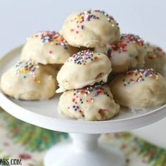 a white plate topped with cookies covered in frosting and sprinkles