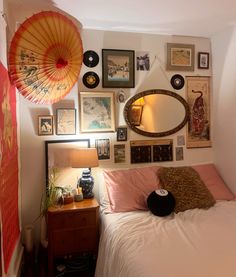 a bedroom with pictures on the wall and an umbrella hanging above it's bed