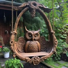 an owl swing with chains hanging from it's sides in front of a house