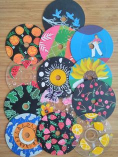 a bunch of different colored discs sitting on top of a wooden table next to each other