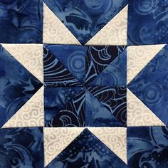 a blue and white patchwork quilt with an intricate design on the center, which has been stitched together