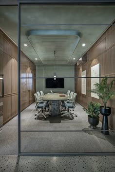 an empty conference room with wooden paneling and glass walls on either side of the table