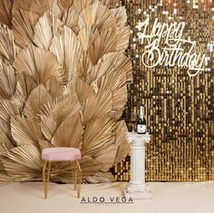 a chair sitting in front of a golden wall with a happy birthday sign on it