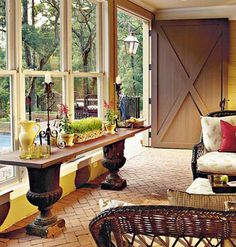 a living room filled with lots of furniture next to a window covered in glass doors