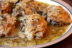 a white plate topped with meat and mushrooms covered in gravy