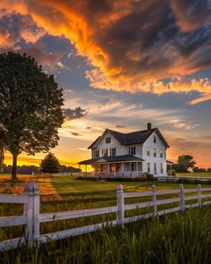 a large white house sitting on top of a lush green field