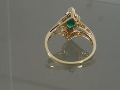 This is a gorgeous bypass ring crafted from 14k yellow gold that features one synthetic marquise chrome diopside accented with two tiny round faceted diamonds on each side. This ring would make a great engagement, promise, anniversary, or right-hand ring. This ring will be shipped in a brand new gift box. RING SIZE: 7.0 (Sizable by your local jeweler) Metal: 14k yellow gold (Verified by acid test) Gemstone: 1 Marquise Synthetic Chrome Diopside (approx. 10.0mm x 5.0mm) & 4 round faceted diamo Classic Marquise Cut May Birthstone Jewelry, Yellow Gold Emerald Jewelry With Marquise Cut, Green Marquise Ring With Diamond Accents, Green Marquise Rings With Diamond Accents, Marquise Cut Emerald Jewelry In Yellow Gold, Green Multi-stone Marquise Jewelry, Green Marquise Birthstone Jewelry, Formal Green Marquise Jewelry, Green Marquise 14k Gold Jewelry