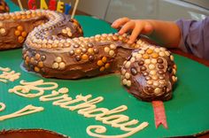 a child is decorating two cakes with candles on them and the words happy birthday spelled out in white letters