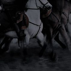 three men riding horses in the dark