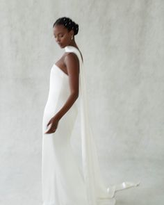 a woman in a white dress with a shawl around her neck