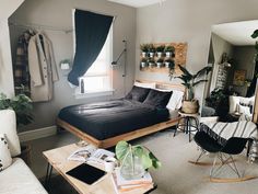 a bed sitting in a bedroom next to a window and a table with two chairs