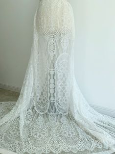 the back of a woman's wedding dress with sheer lace and beading on it