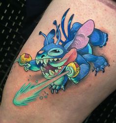 a colorful tattoo on the leg of a person with a toothbrush in his mouth