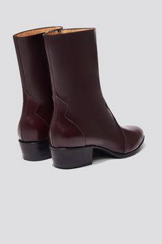 The Guada is a Western-inspired boot silhouette with stripped down detailing. An almond shaped toe, welted outsole and low stacked heel make this style feel feminine and powerful. A black base keeps the vibe modern and sleek. Featuring a mid-height shaft that extends to the low calf, this boot is designed to disappear under hems of cropped skirts and trousers without adding the unnecessary bulk of a taller shaft. The heel height makes this a great everyday style, while the toe shape dresses up y Boot Silhouette, Wool Overcoat, Almond Shaped, Western Boot, Deep Burgundy, The Vibe, Western Cowboy Boots, Vegetable Tanned Leather, Stacked Heel