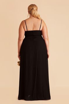 a woman in a black dress with her back to the camera