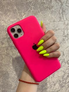 a woman's hand holding an iphone case with neon yellow nails