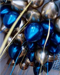 blue and silver balloons are hanging from the ceiling