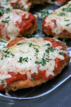 chicken parmesan on a plate with cheese and herbs