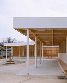 an empty covered parking lot with wooden benches