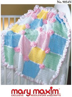 a crocheted baby blanket with flowers on it in pink, yellow and blue