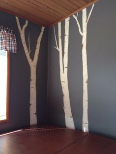 a room with some trees painted on the wall