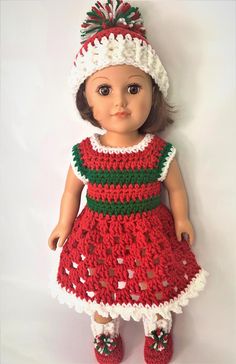 a crocheted doll is wearing a red dress and white hat with green trim