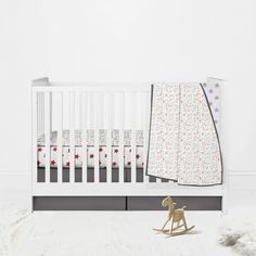 a white crib with a toy horse next to it