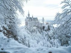 a castle is surrounded by snow covered trees