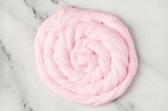 a pink ball of yarn sitting on top of a marble surface