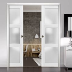 an open door leading to a bedroom with white furniture