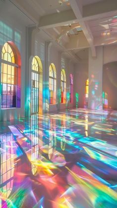 an empty room with many windows and colorful lights on the floor