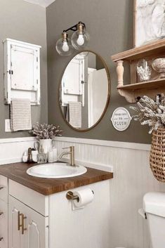 a bathroom with a toilet, sink and mirror in it's corner area is shown