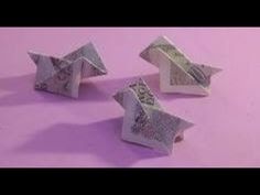 three origami stars and one dollar bill on a pink tablecloth with purple background