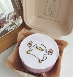 a cake in a box with an image of a duck on it's side