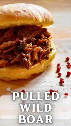 the pulled wild boar sandwich has been cut in half and is ready to be eaten