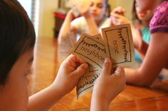 two children are sitting on the floor and playing with some sort of card board game