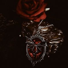 a red rose sitting on top of a black box next to a skull and cross