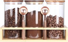 three glass jars filled with different types of coffee beans and cereals on wooden shelves