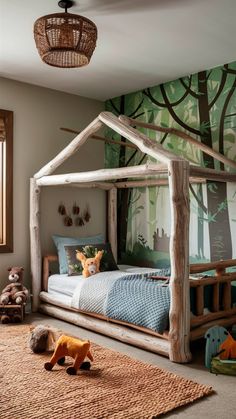 a child's bedroom with a bed made out of wood and a forest theme on the wall