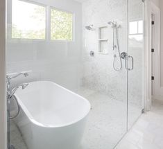 a white bath tub sitting next to a walk in shower