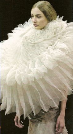 a woman in a white dress with ruffles on it