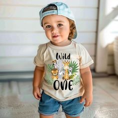 a little boy that is standing up wearing a t - shirt with animals on it