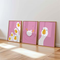 three framed pictures of ducks in pink and white on the wall next to each other