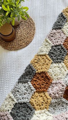 a crocheted rug with a potted plant next to it