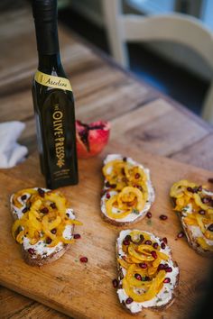 some food is laying on a cutting board with a bottle of wine in the background