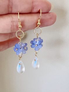 Embrace the timeless beauty of these handmade earrings adorned with delicate little blue "Forget Me Not" flowers, symbolizing love and fidelity.  Suspended from each blossom, glistening crystal drops add a touch of sparkle and allure. With their understated charm and handmade craftsmanship, they make a captivating addition to any ensemble, infusing it with grace and romance. A perfect gift for her, these earrings exude elegance, making them an exquisite choice for bridal wear or as a captivating Blue Flower Charm Drop Earrings, Delicate Blue Flower Earrings With Ear Wire, Blue Drop Flower Earrings With Ear Wire, Light Blue Crystal Earrings For Gift, Blue Drop Flower Earrings, Blue Pierced Flower Earrings Gift, Blue Drop Earrings With Flower Charm, Blue Flower Shaped Jewelry With Ear Wire, Blue Pierced Flower Earrings For Gifts